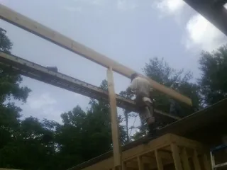 Carpenter setting a ridge beam over a new addition frame — Ice Dam Removal by Roofing Brothers in Ruckersville