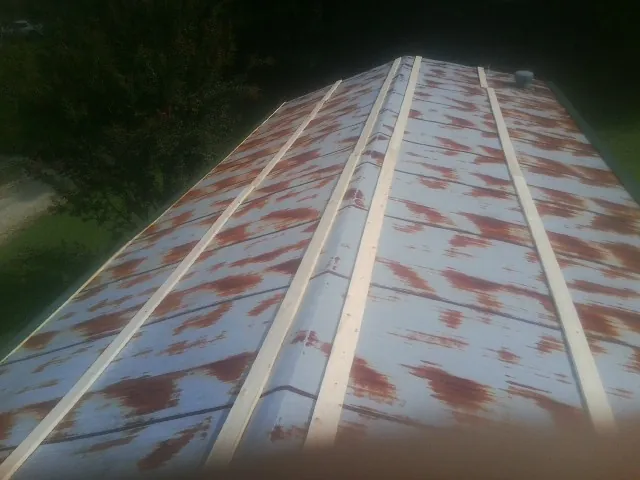 Rusted metal roof panels with new wood purlins before replacement — Storm Damage Roof Repair in Ruckersville by Roofing Brothers