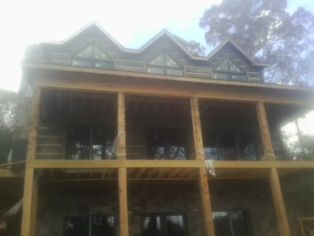 Dormers and porch framing on a large log home under construction — Roof Coating work by our crew in Ruckersville