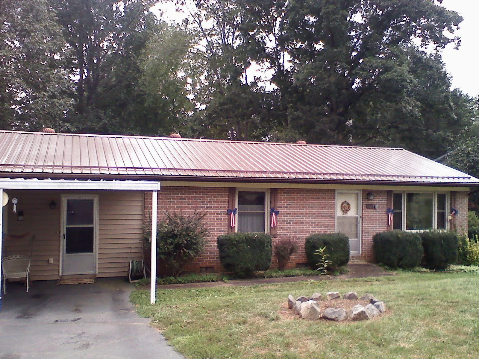 Bronze metal roof and carport on a brick ranch home — Roof Repair work by our crew in Ruckersville